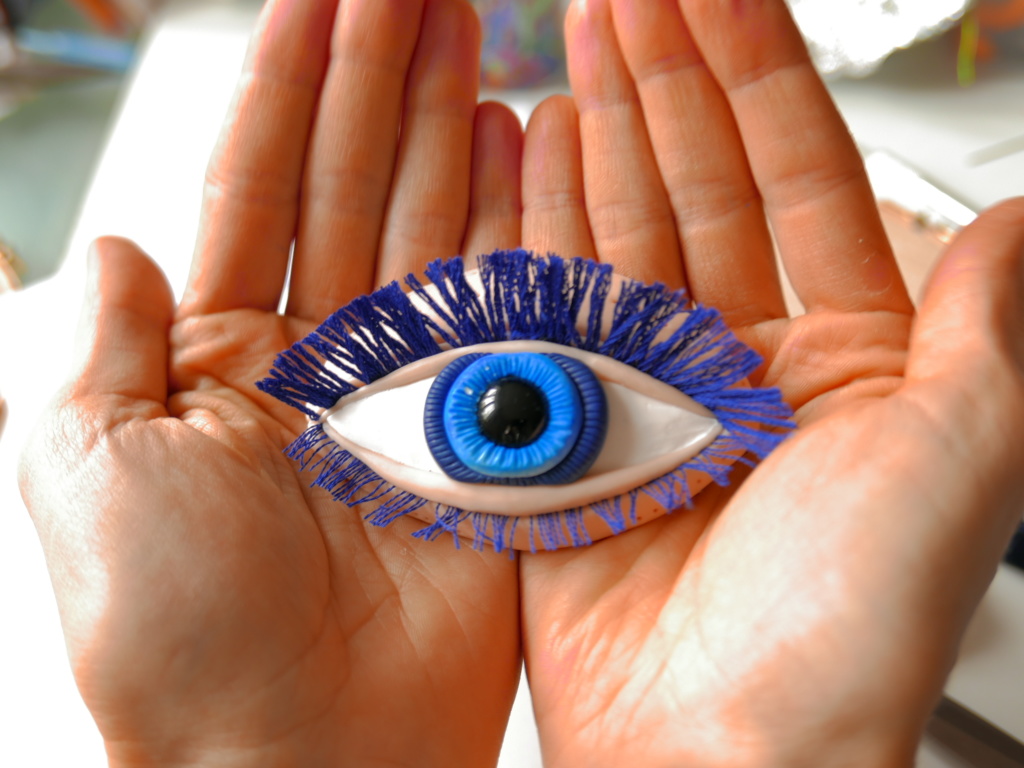 polymer clay eye in two hands