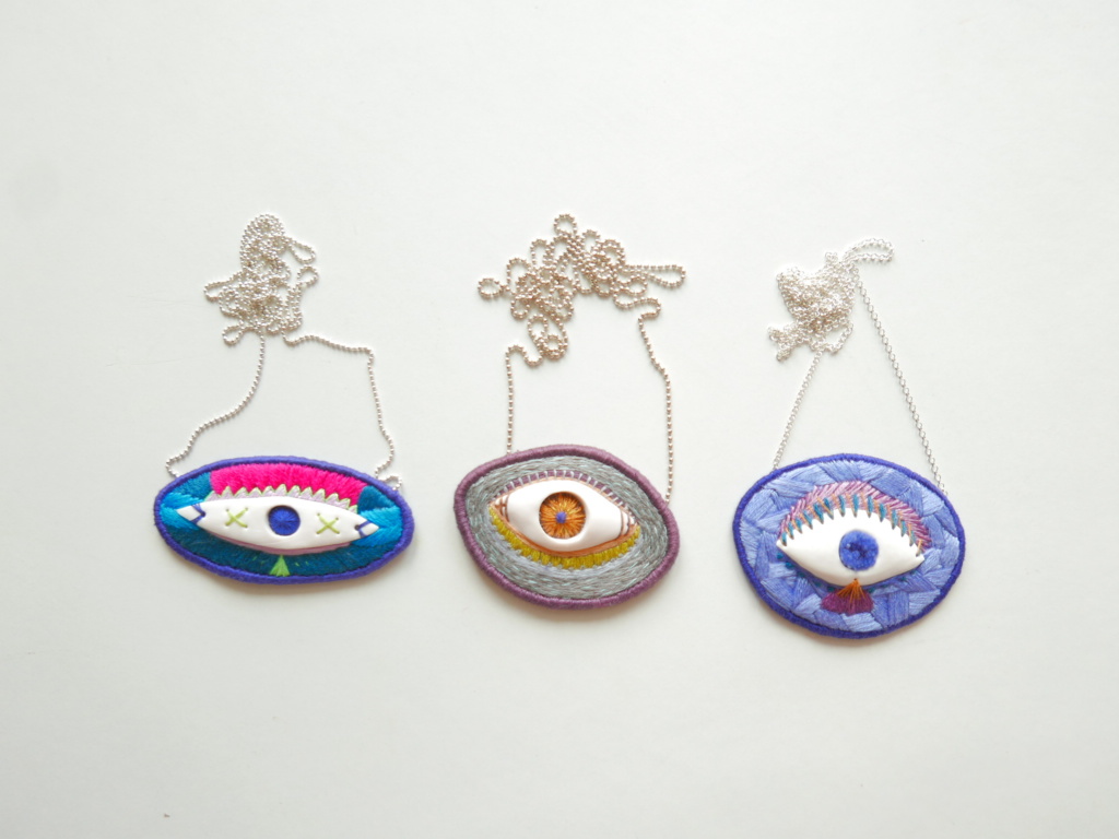 three hand embroidered necklaces with eyes
